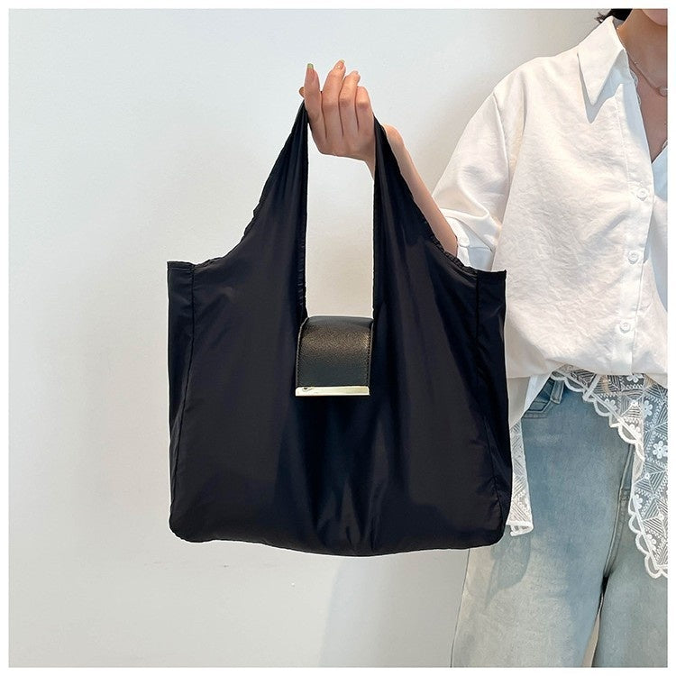 Foldable Lightweight Shoulder Bag shown being held with a key ring capsule bag attached.