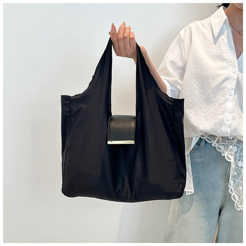 Foldable Lightweight Shoulder Bag shown being held with a key ring capsule bag attached.