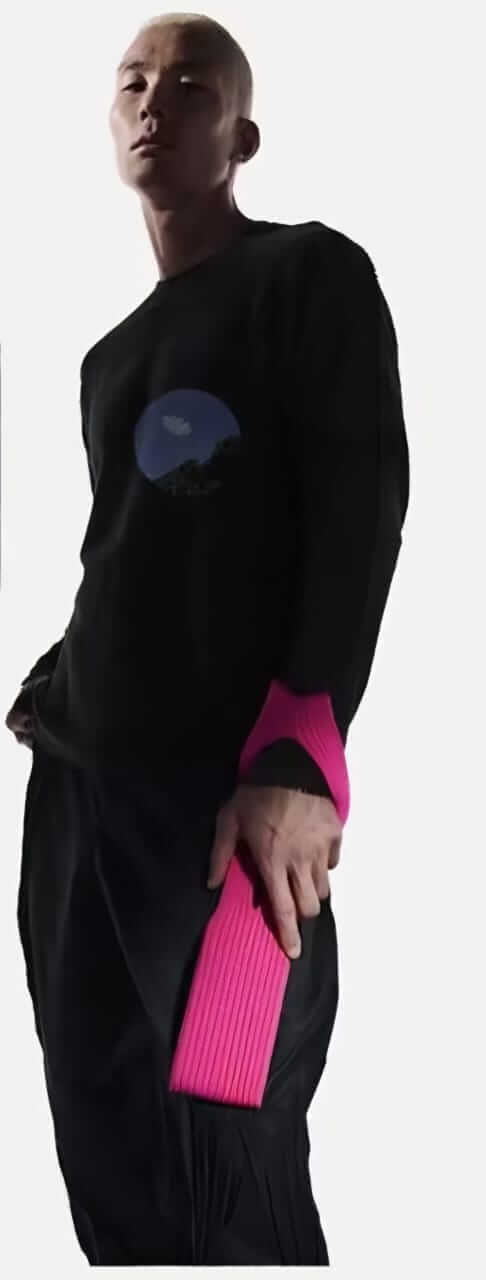 Stylish model showcasing the Mobile Pocket accessory in a vibrant pink color, paired with a black sweater.