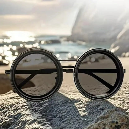 Adjustable Tint Sunglasses: SmartShade HD resting on a rock near water, showcasing their stylish round design.