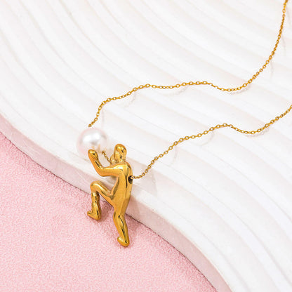 Ambition pearl necklace featuring a gold figure holding a pearl on a delicate chain against a textured background.