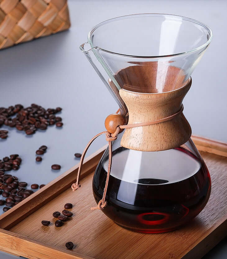 Chemex Coffee Maker on a wooden tray with coffee beans and brewed coffee, highlighting its premium glass design.