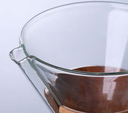 Close-up of Chemex Coffee Maker glass pour over brewer showing pouring spout and wooden base.