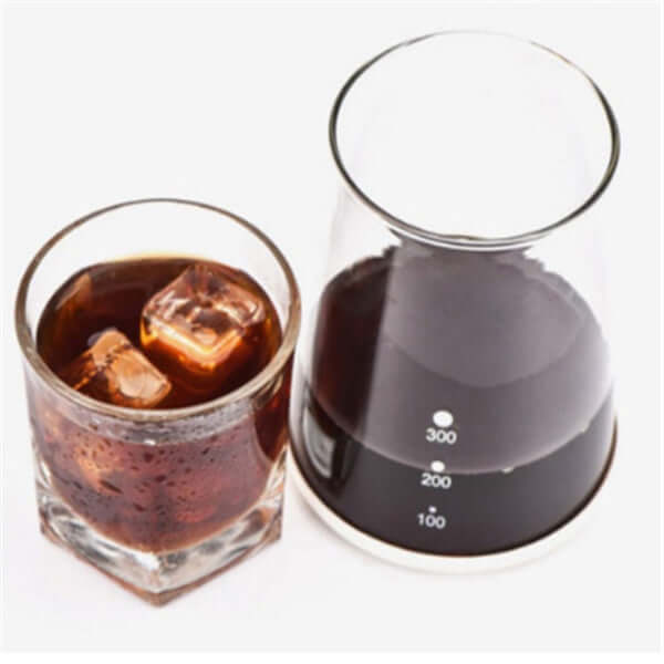 Cold drip coffee maker featuring a glass container and a drink with ice cubes, showcasing smooth coffee extraction.