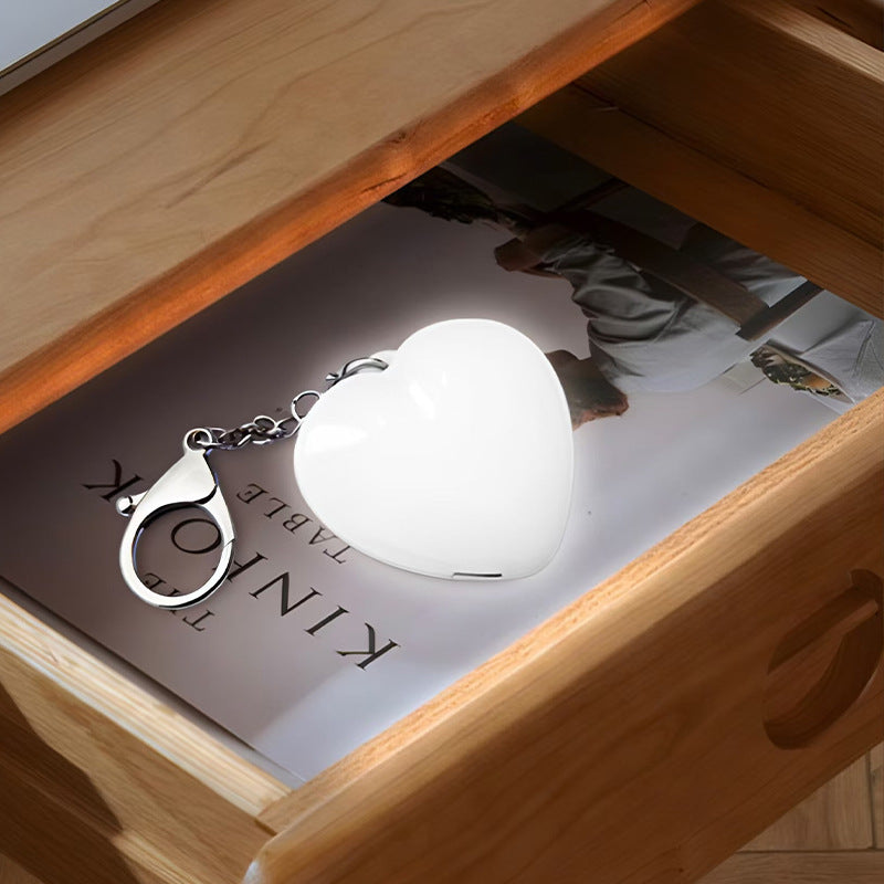 Heart Shaped Bag Light – The LUMI-HEART Glowing Handbag Charm illuminating a drawer with magazines.