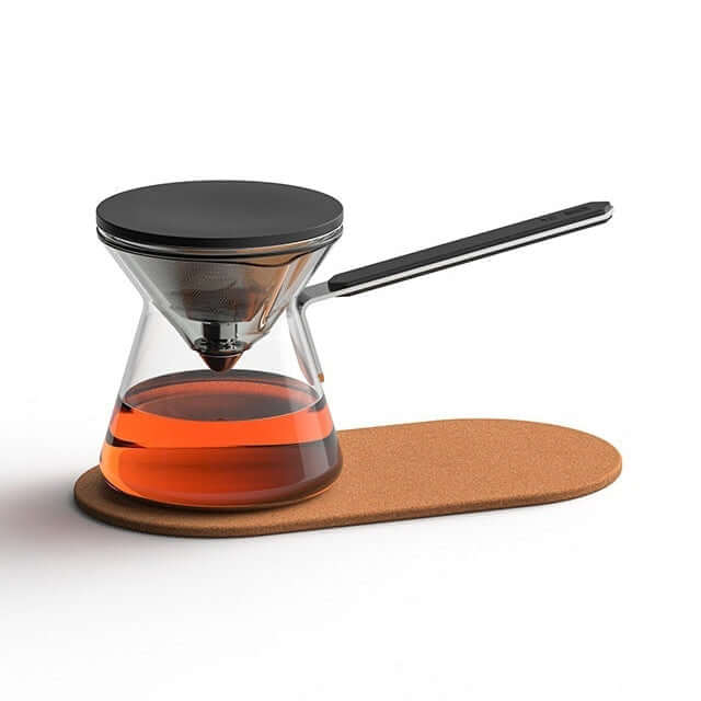 Magnetic Tea Pot - Chroma Glass Press-Type Infuser with tea on a cork base, showcasing a modern brewing design.