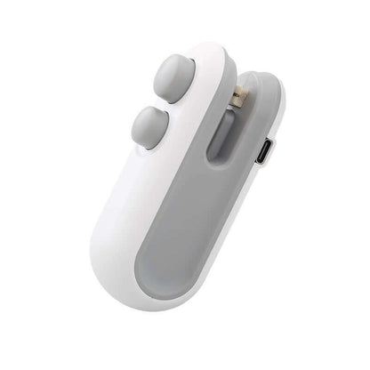 A white Mini 2-in-1 Rechargeable Heat Sealer being used to seal a snack bag, showcasing its compact, handheld ergonomic design.