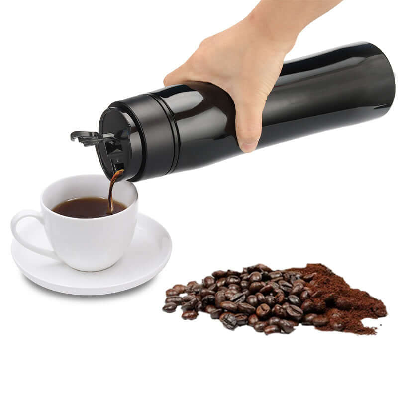 Portable Espresso Maker pouring coffee into a cup beside coffee beans and ground coffee.