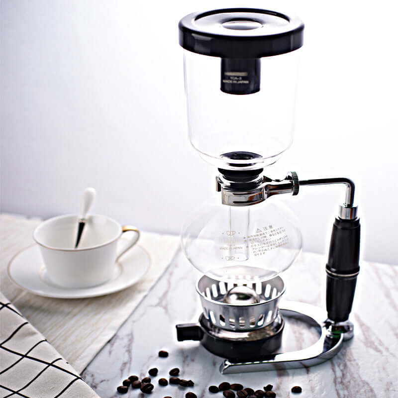 Premium Siphon Coffee Maker on countertop with coffee beans and cup.