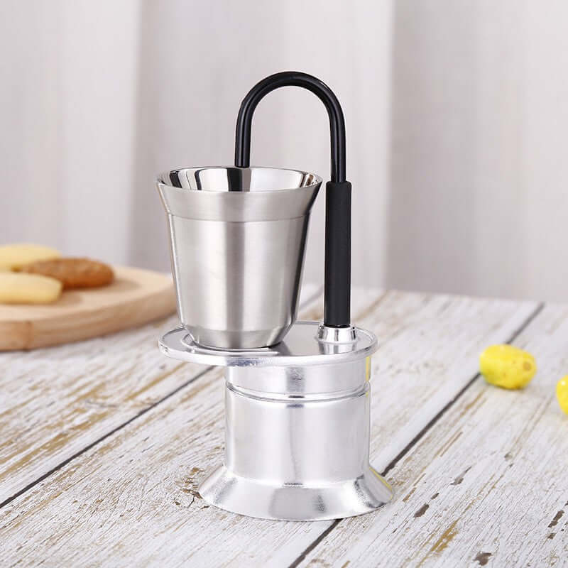 Single-Shot Aluminum Moka Pot with a classic octagonal design and heat-resistant handle on a minimalist kitchen counter.
